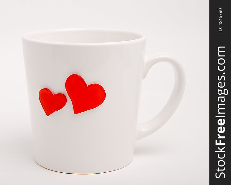 White cup with heart-shapes on a white background, isolated