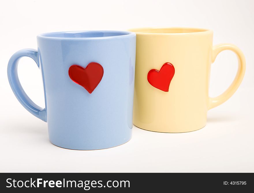 Two cups with hearts on a white background