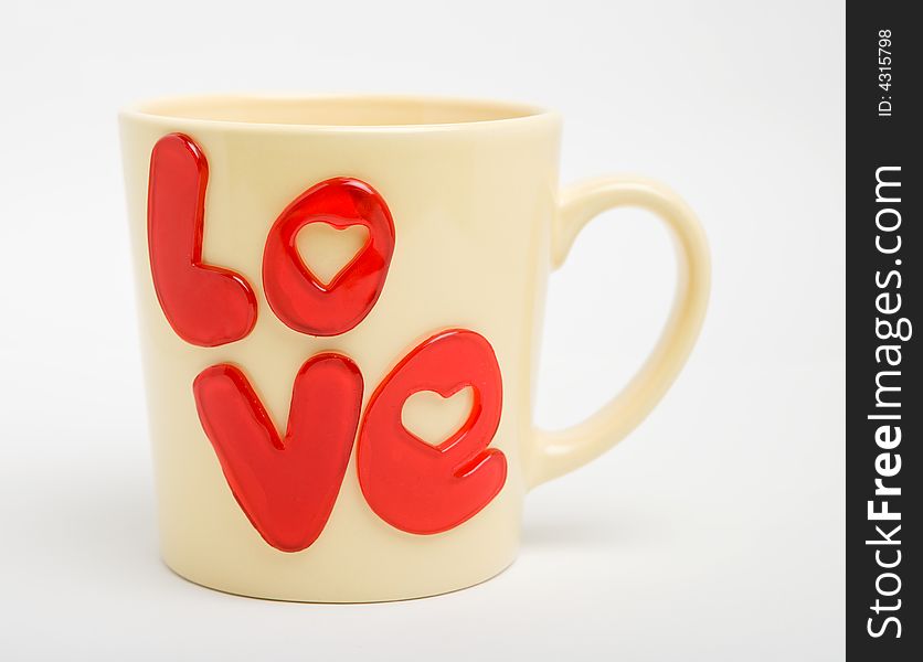 Yellow cup with love-word on a white background, isolated. Yellow cup with love-word on a white background, isolated