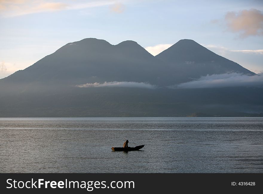 Fisherman on the lake under volcano mountain