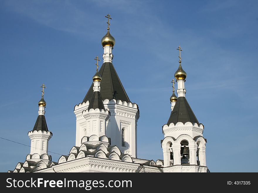 White church with black roof and blue sky. White church with black roof and blue sky