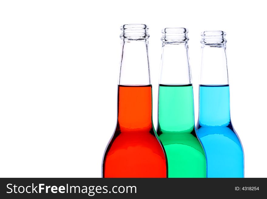 Bottles with red, green, and blue liquid closeup isolated on white. Bottles with red, green, and blue liquid closeup isolated on white