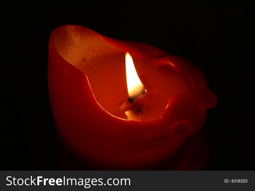 A candle on black background