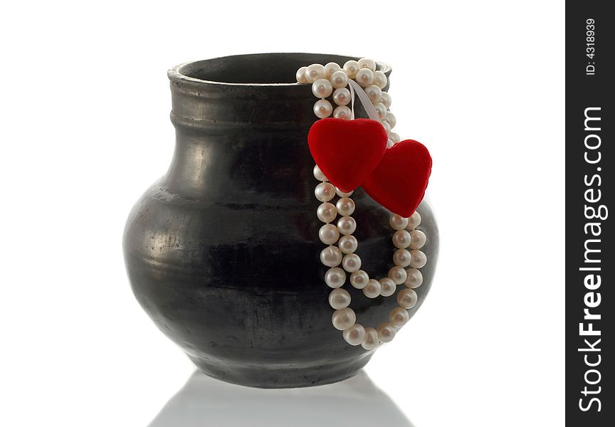 The thread of pearls and hearts hang down from a vase. The thread of pearls and hearts hang down from a vase