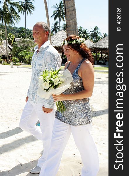 Bride and groom on their tropical beach destination wedding day. Bride and groom on their tropical beach destination wedding day.