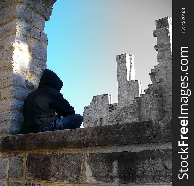 A boy sits on a castle window looking out into the past. A boy sits on a castle window looking out into the past.