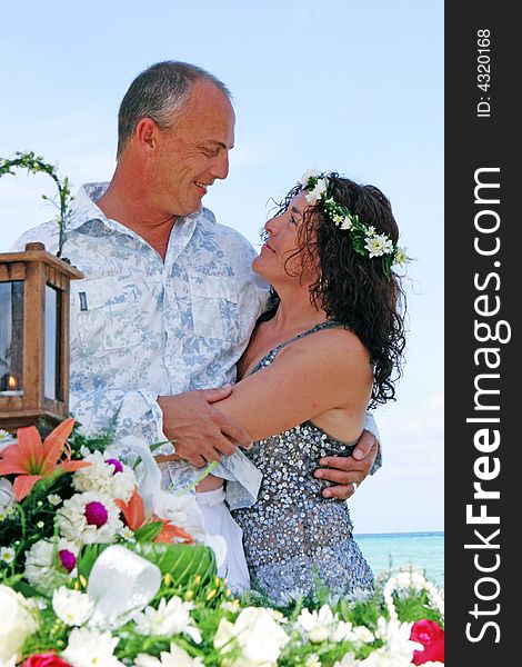 Bride and groom on their tropical beach destination wedding day. Bride and groom on their tropical beach destination wedding day.