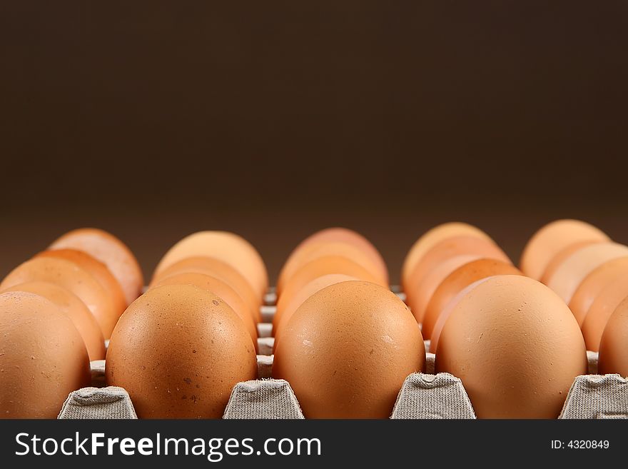 24 eggs in tray over brown background