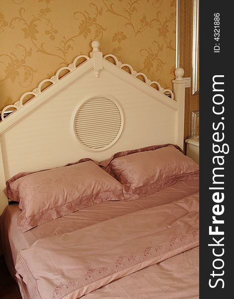 A pink comfortable bed in a beautiful bedroom.