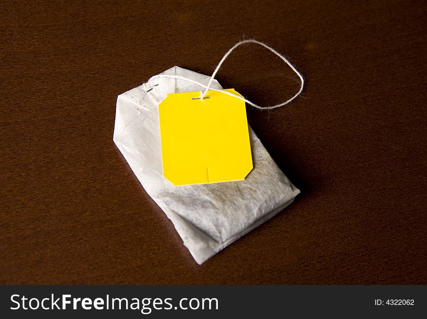 Tea in yellow bags on a brown background. Tea in yellow bags on a brown background