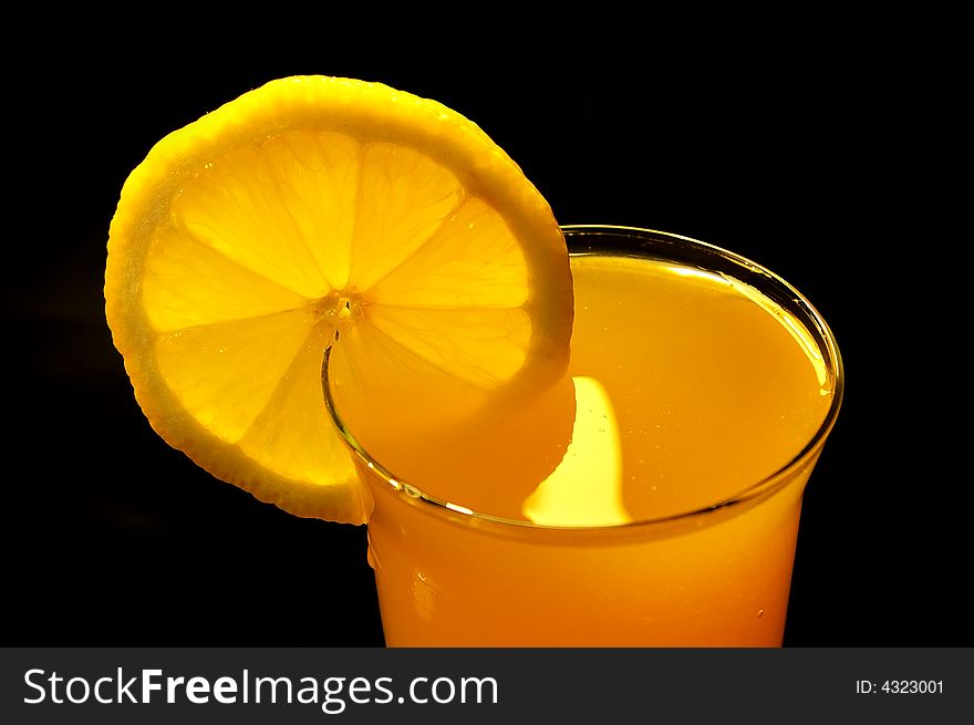 Oranges juice in the glass on black background