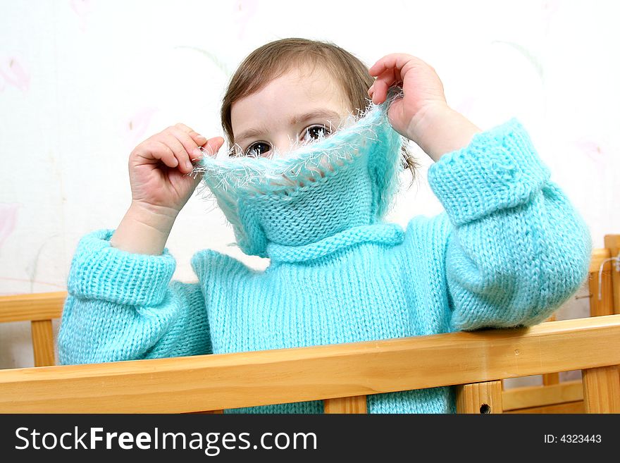 Little girl hides face behind collar of jacket
