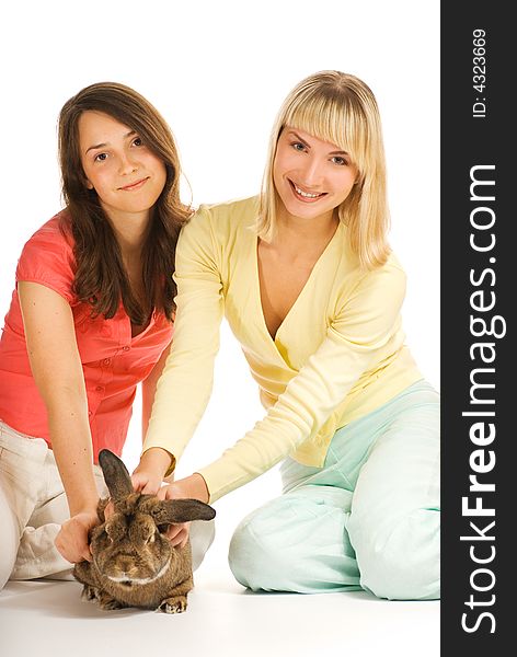 Two girls playing with bunny isolated on white background