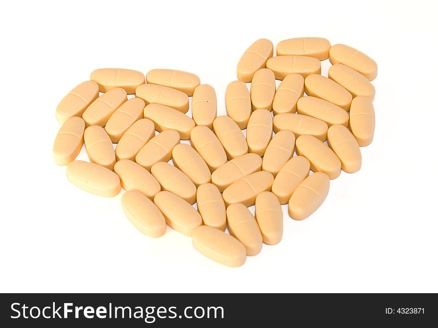 Heart-shaped pile of pills on white background. Heart-shaped pile of pills on white background