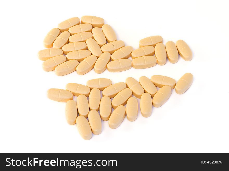 Heart-shaped pile of pills splited by half with pencil on white background. Heart-shaped pile of pills splited by half with pencil on white background