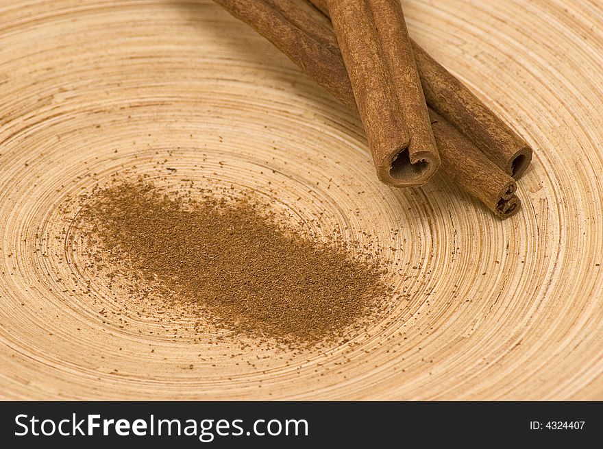 Powdered cinnamon with pieces of cinnamon on the bamboo platter