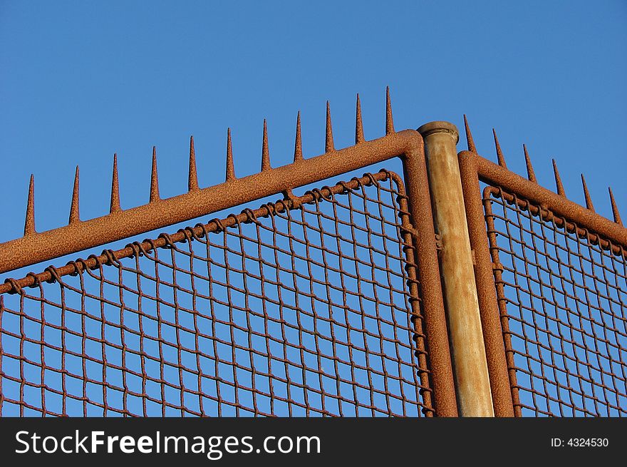 Rusty old fence with a blue sky background