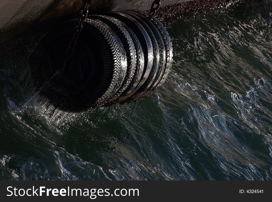 Tires on the pier tide for ship safety. Tires on the pier tide for ship safety