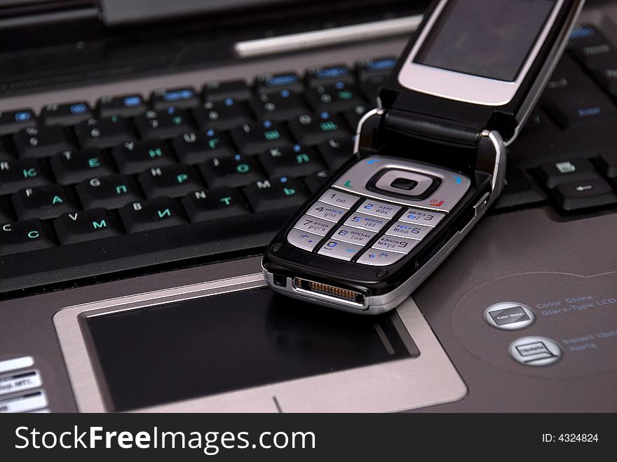 Keyboard of laptop and smartphone on it.