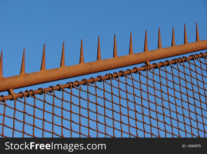 Rusty old fence with a blue sky background