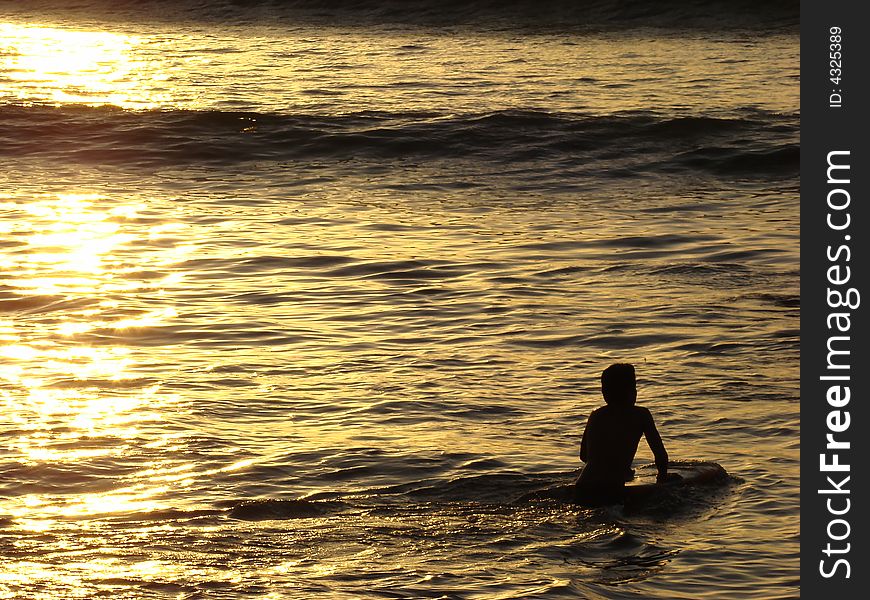 Pacific Ocean body boarder in the setting sun. Pacific Ocean body boarder in the setting sun.