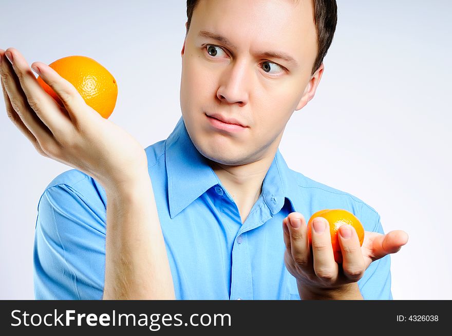 Man in a shirt with two fresh bright oranges. Man in a shirt with two fresh bright oranges