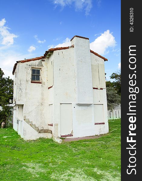 Abandoned old house with blue sky background and green grass foreground