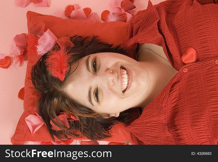 Young beautiful woman laying on a red pillow