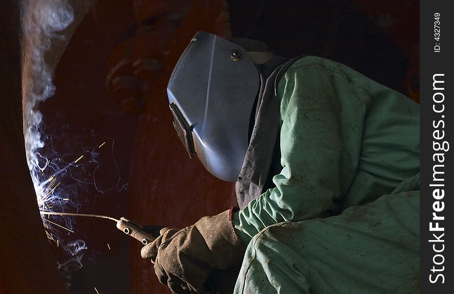 A welder working at shipyard at night. A welder working at shipyard at night