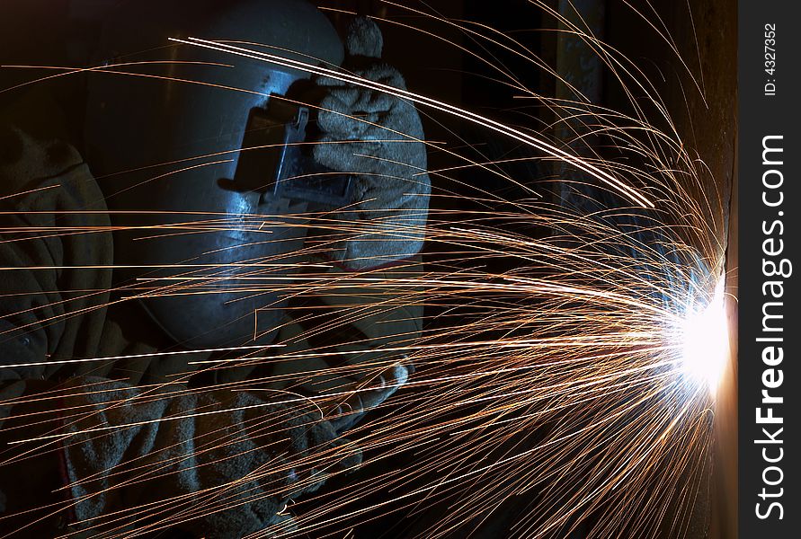 A welder working at shipyard at night. A welder working at shipyard at night