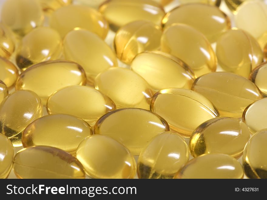 Many scattered oval, yellow pills forming an abstract background. Many scattered oval, yellow pills forming an abstract background