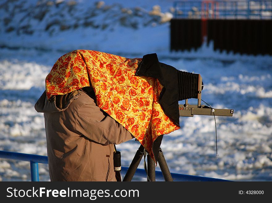 Photographer under a cover while taking picture. Photographer under a cover while taking picture.