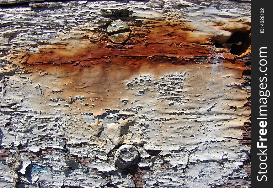 White and rusty peeling paint on old board