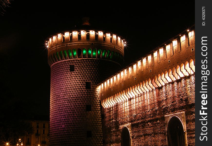 A tower of Castello Sforzesco in Milan by night