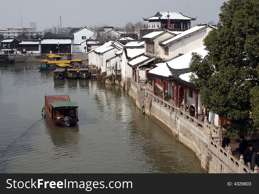 The beautiful and enjoyable snow scenery in the winter in the southern part of China. These sceneries are famous for their snow ,water, houses,and the blue sky.They are typical of the south in China.This picture is taken in the place of interestâ€œMooring by the Feng Bridge at nightâ€ in Suzhou ,China.