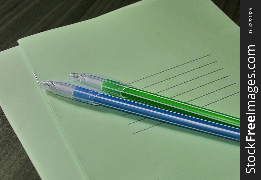 Back to school concept. Thin green notebooks with two handles on the table