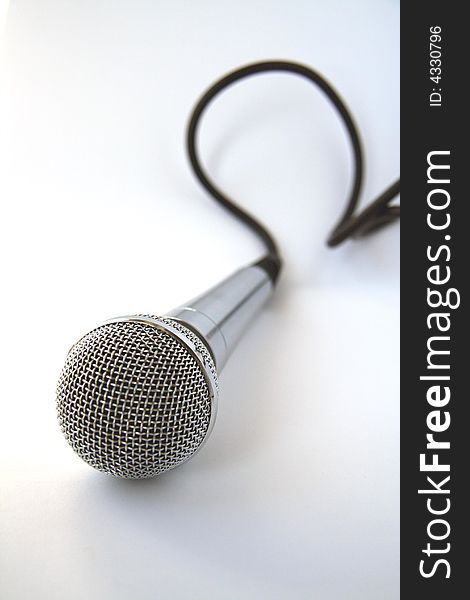 Microphone with a black cord on a white background. Microphone with a black cord on a white background.