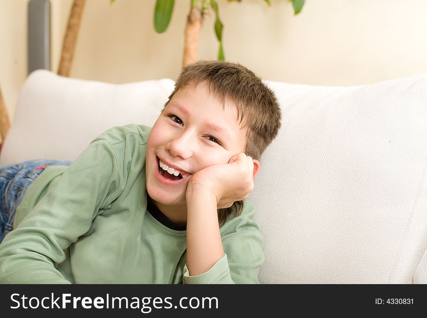 Happy Teenager Lie On Sofa At Home