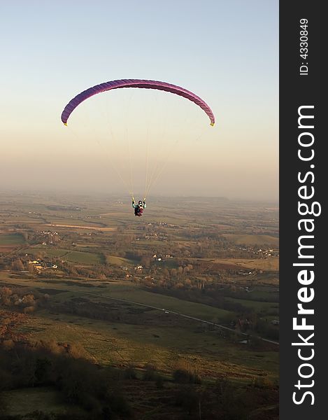 A Paraglider takes off for his last flight as the light fades over the Malvern Hills in Worcestershire, UK.