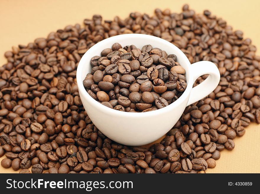 White coffee cup with coffee beans on yellow background