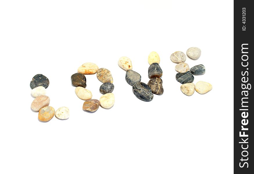 'Love' word written with stones of different shapes and colours on a white background. 'Love' word written with stones of different shapes and colours on a white background