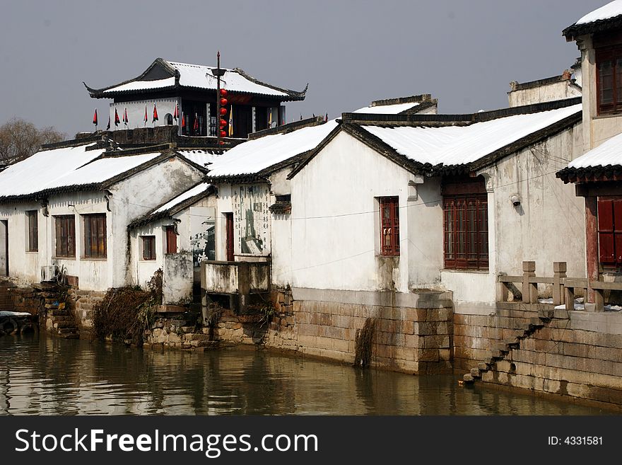 The beautiful and enjoyable snow scenery in the winter in the southern part of China. These sceneries are famous for their snow ,water, houses,and the blue sky.They are typical of the south in China.This picture is taken in the place of interestâ€œMooring by the Feng Bridge at nightâ€ in Suzhou ,China.