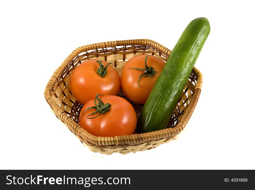 An isolated crib (basket) with tomatoes and cucumber. An isolated crib (basket) with tomatoes and cucumber