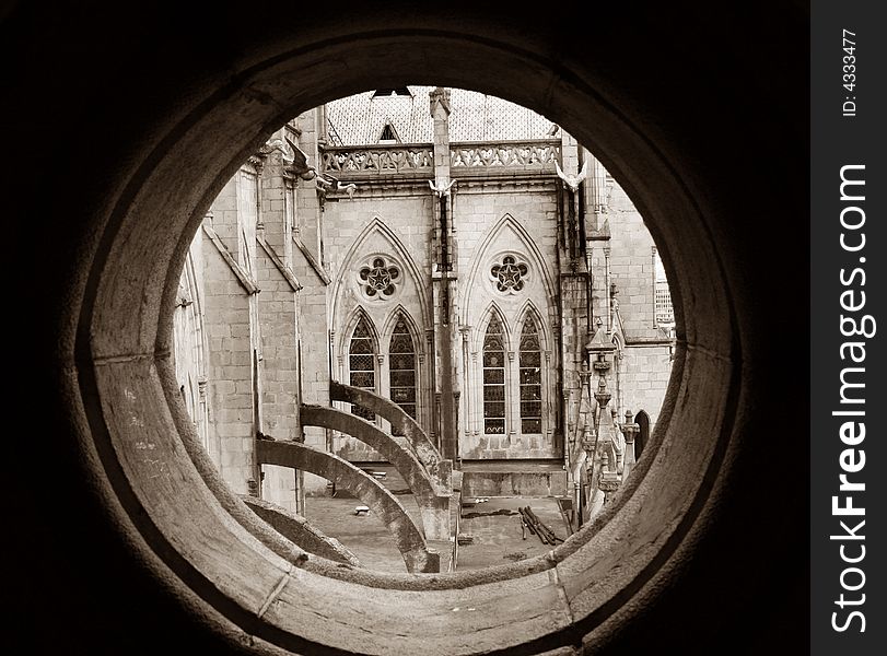 View of the Basilica del Voto National through a round stone window. In the old part of Quito, Ecuador. View of the Basilica del Voto National through a round stone window. In the old part of Quito, Ecuador