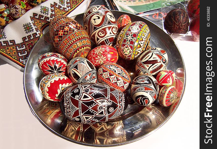 Painted Easter eggs on the dish, placed on the embroidered table-cloth