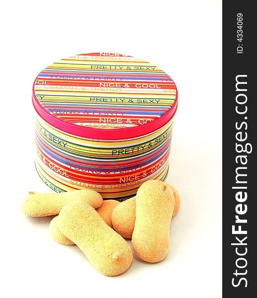 Colourful closed tin with crumbly cookies on a white background. Colourful closed tin with crumbly cookies on a white background