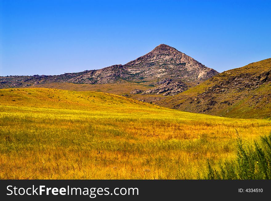 Pyramidal mountain in yellow field. Pyramidal mountain in yellow field