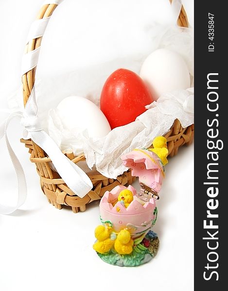 Basket with red and white eggs and bunny figurine. Basket with red and white eggs and bunny figurine