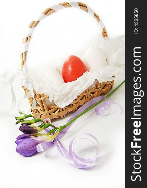 Basket with red and white eggs and violet freesia. Basket with red and white eggs and violet freesia