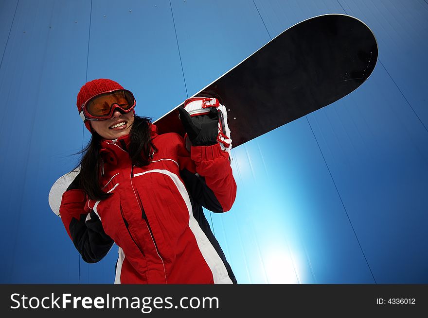 A lifestyle image of a young adult female (age 20-25) snowboarder. A lifestyle image of a young adult female (age 20-25) snowboarder.